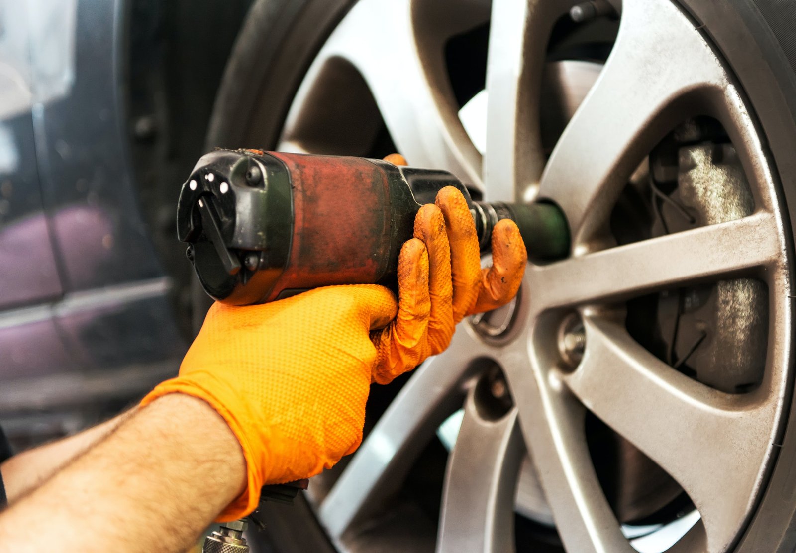 mechanic-unscrewing-car-wheel-with-impact-wrench.jpg